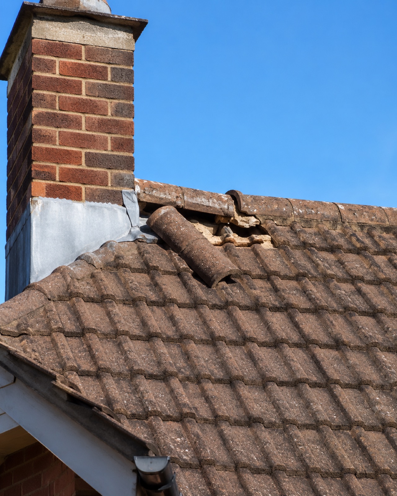Fallen ridge tiles around the base of a chimney