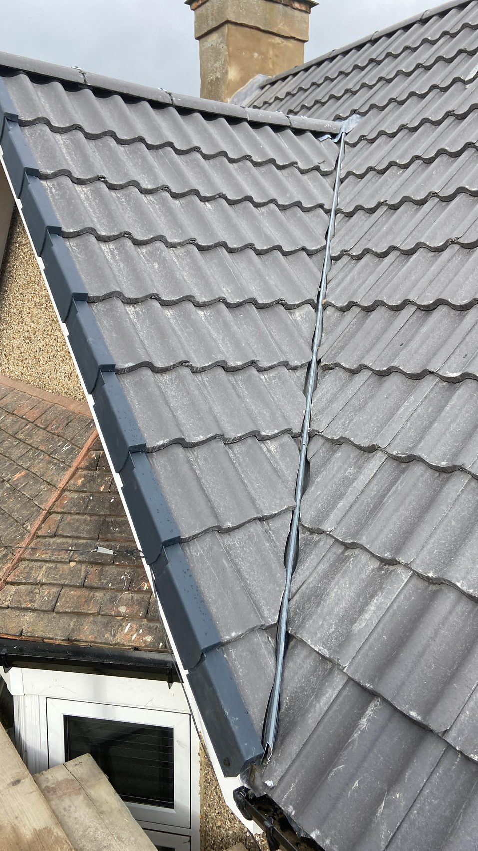Finished grey tiled roof valley with new lead and white fascia, Bedford
