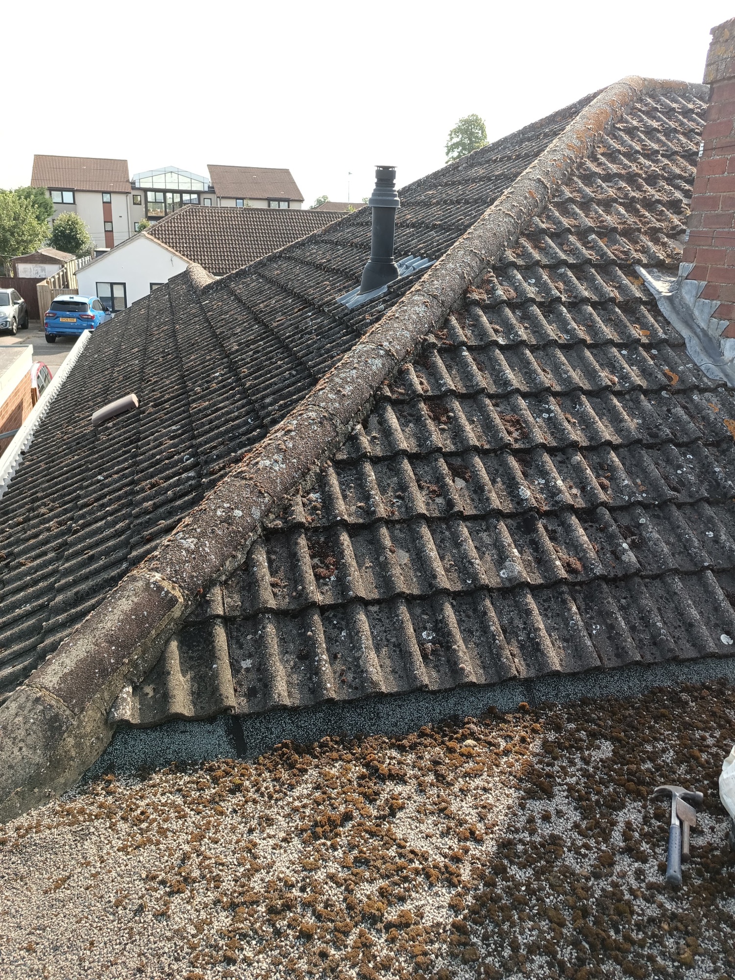 Weathered hip line with slipped cut tiles and tired bedding before the repair