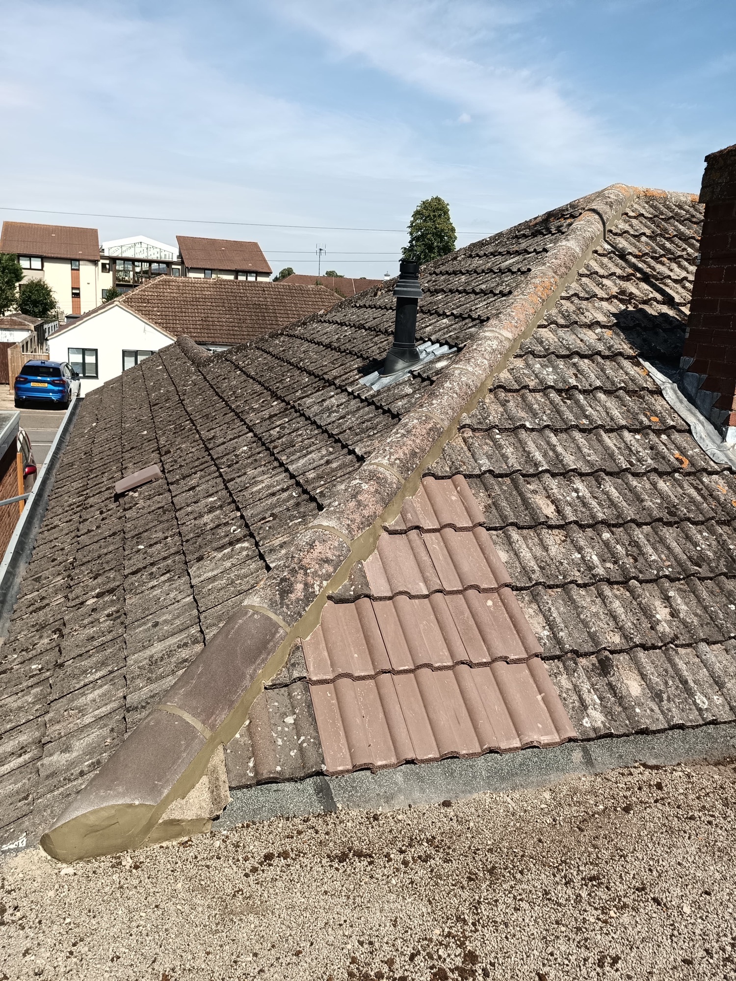 Freshly rebedded hip line in new mortar with replacement cut tiles on a Bletchley roof