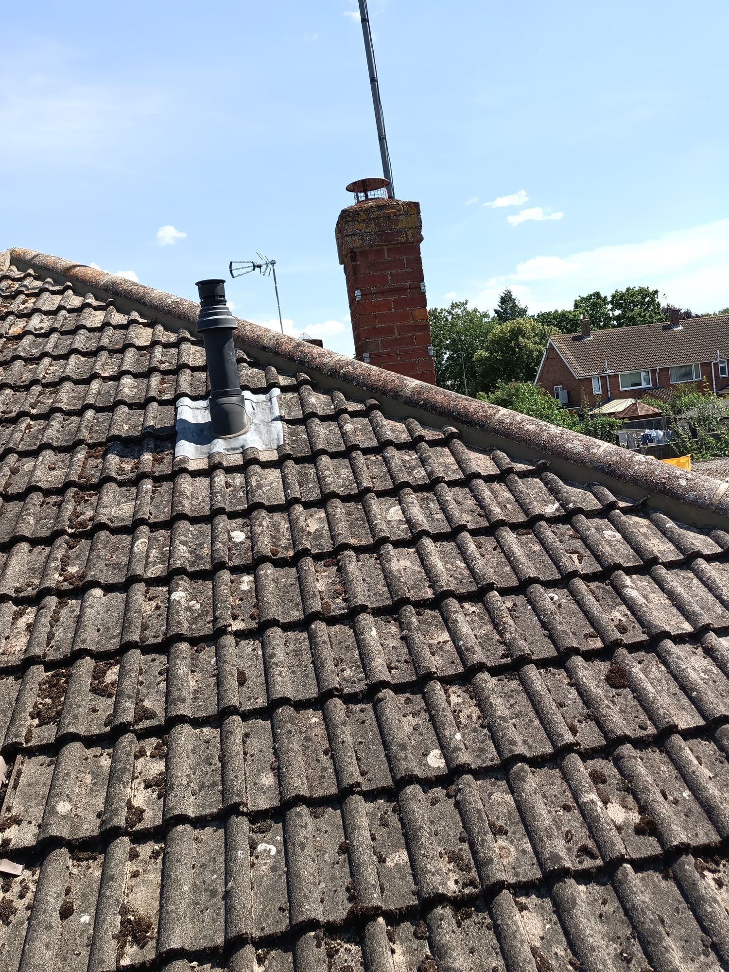 Bletchley pitched tiled roof with a rebedded hip line against blue sky