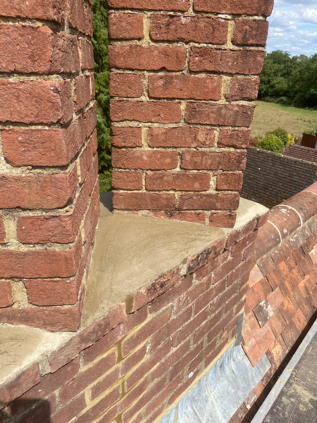 Repointed twin chimney stack with fresh mortar between the flues