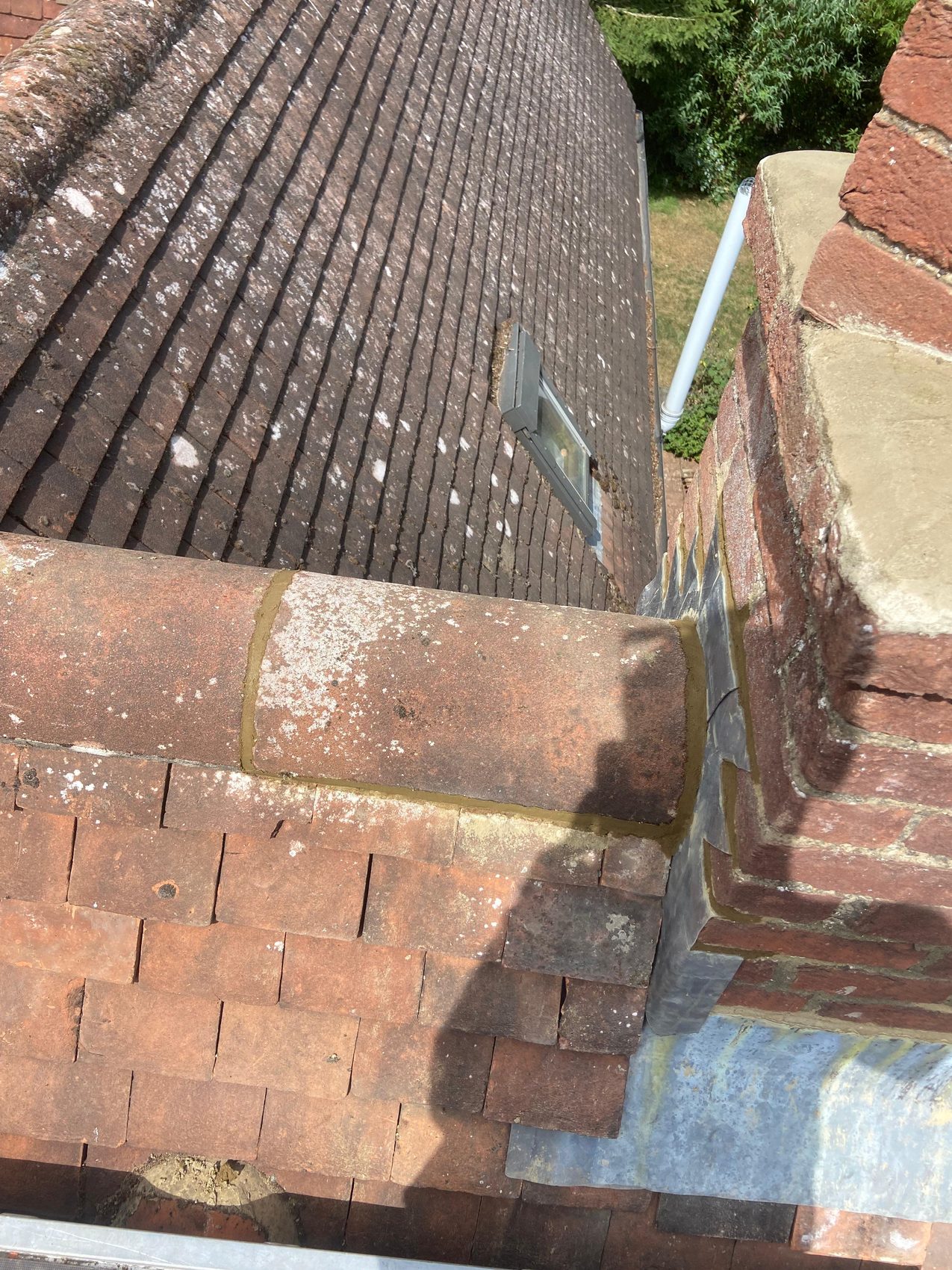 Re-bedded half round ridge line and lead flashing running to the chimney