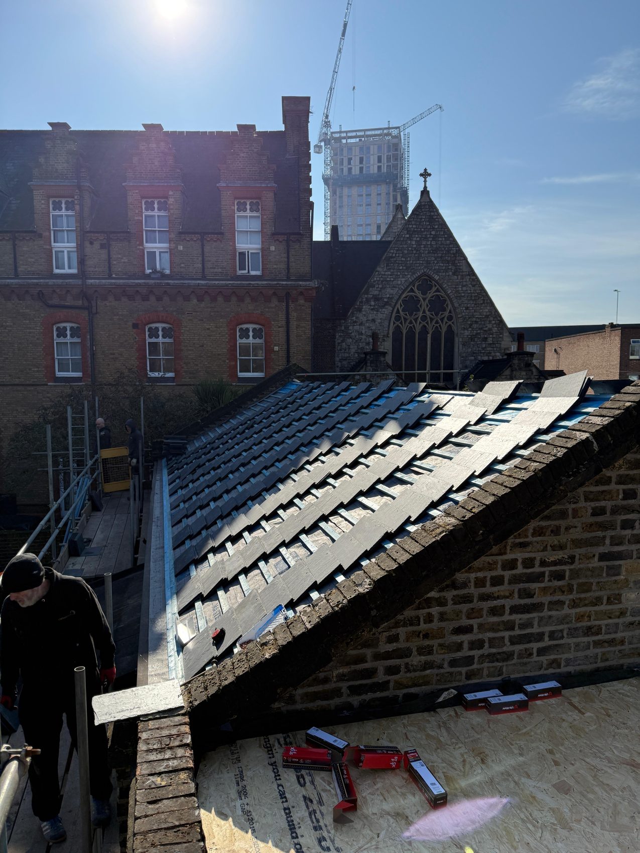 Natural slate courses rising up the pitched roof from the parapet gutter