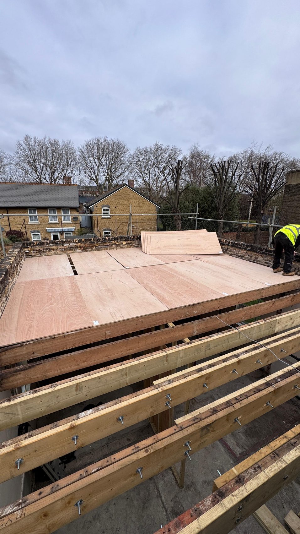 New joists bolted in and fresh decking framing out the rebuilt flat roof