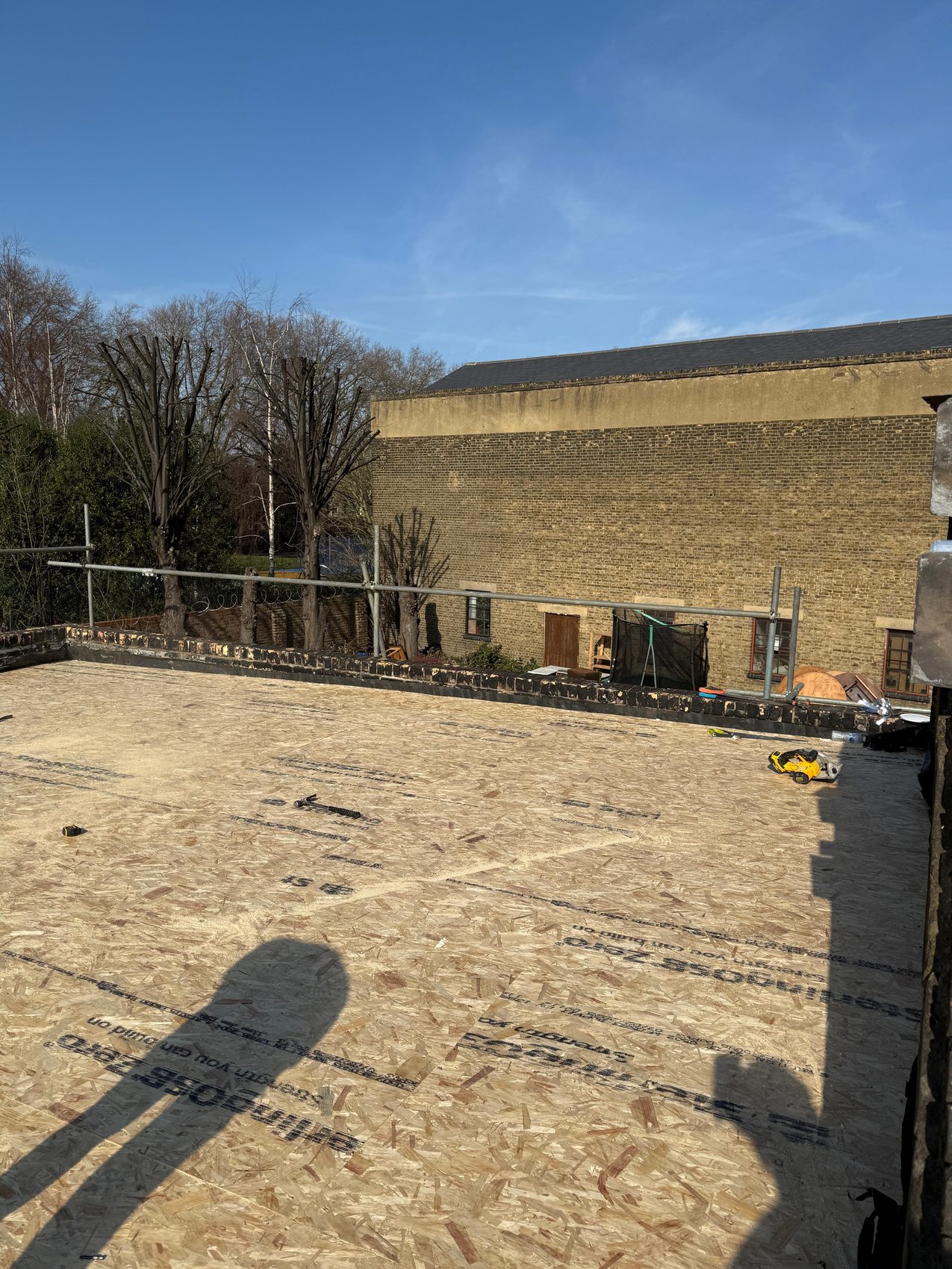 Fresh OSB decking laid out across the rebuilt flat-roof structure