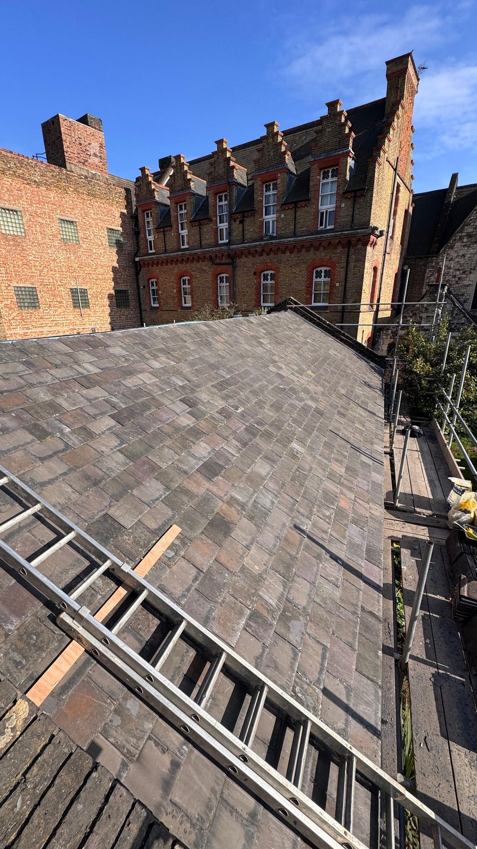 The completed natural slate roof laid in even courses against the heritage brickwork