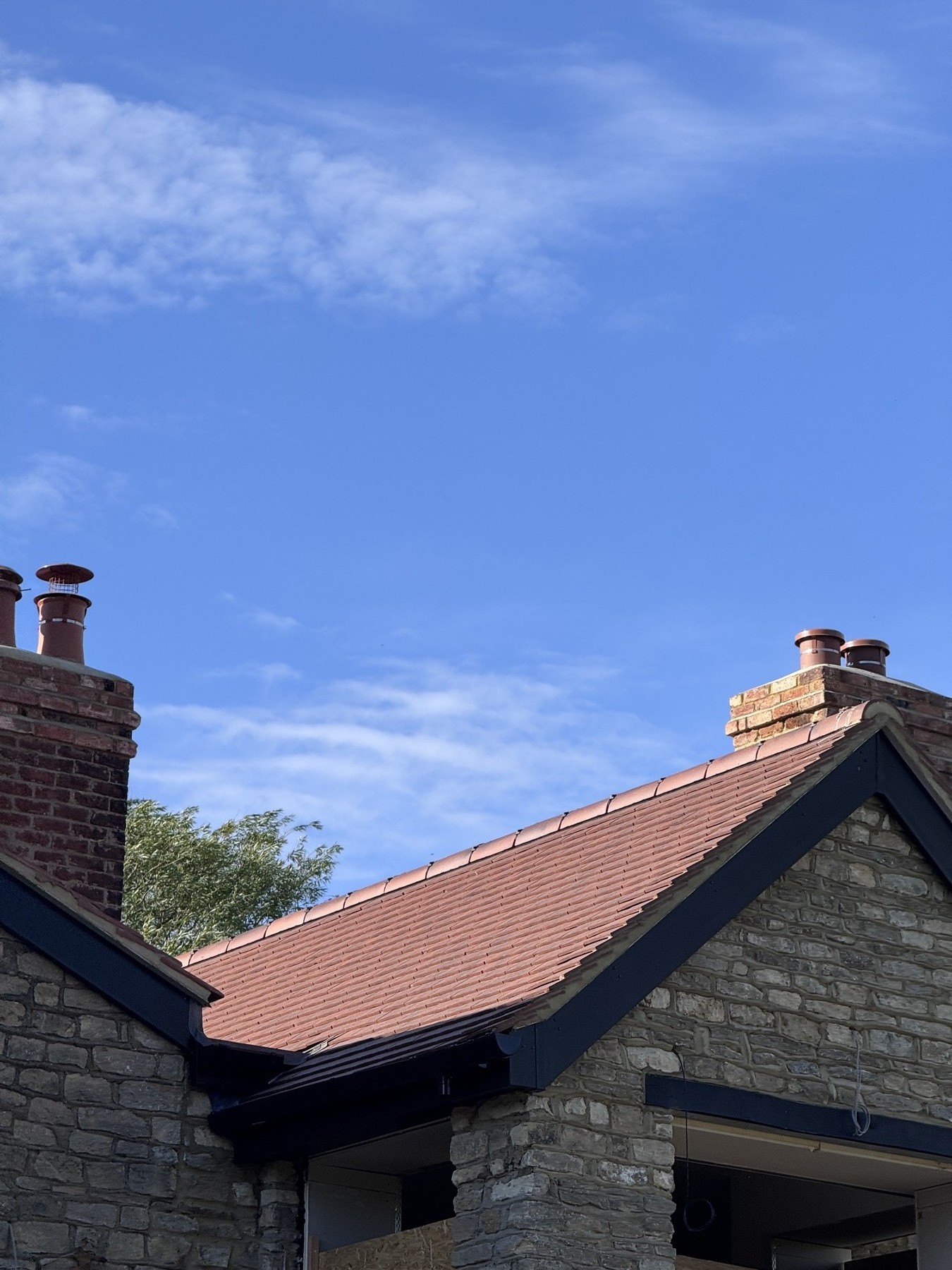 Two rebuilt brick chimney stacks with new terracotta pots and dressed lead flashing on a Buckinghamshire property