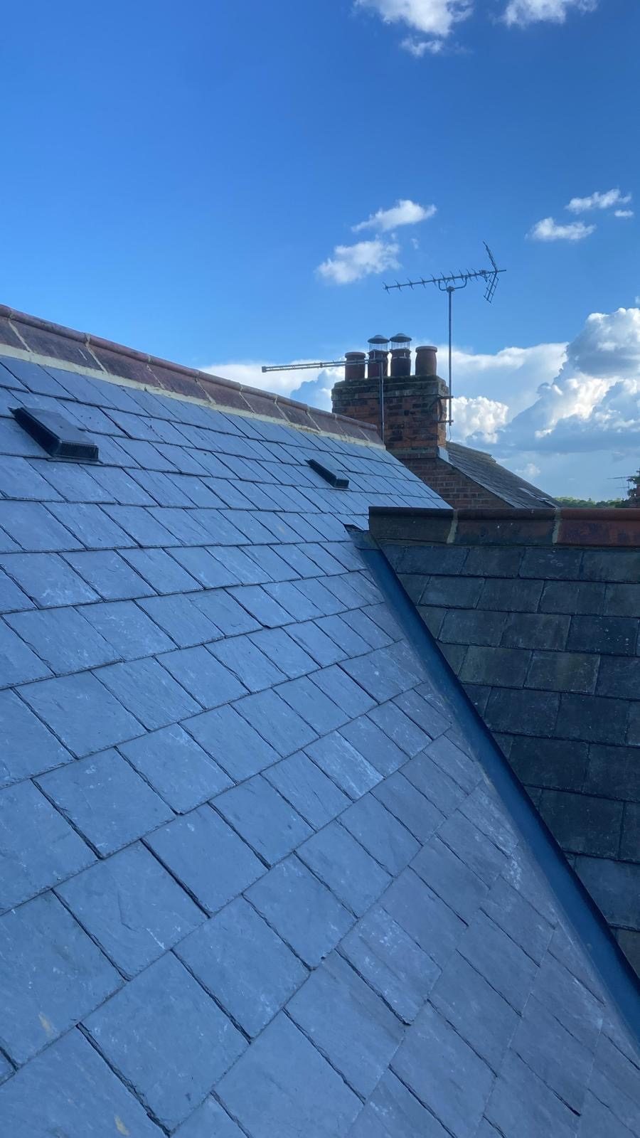 Reclaimed natural slate roof finished under a blue sky