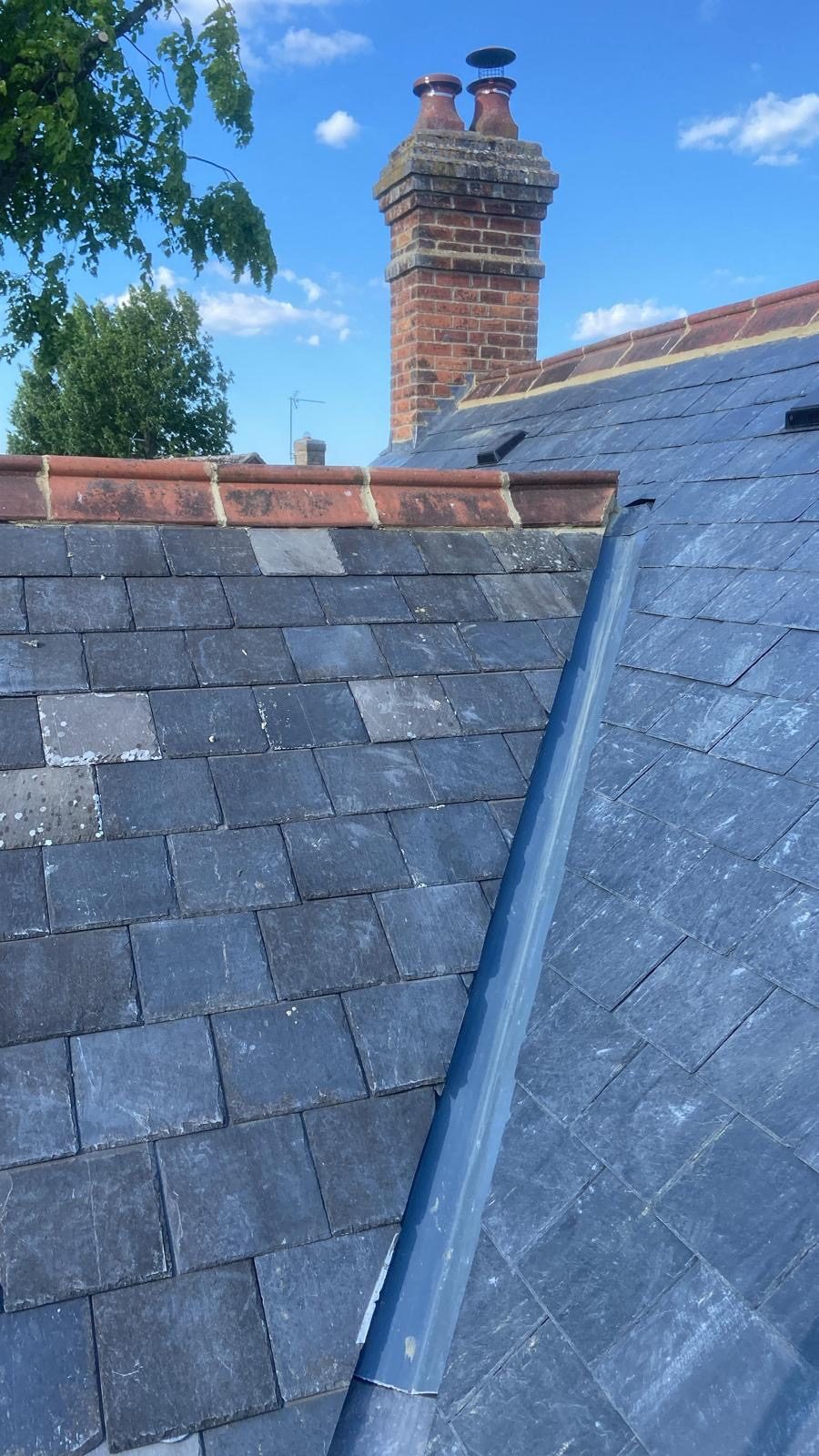 Reclaimed slate roof with a lead hip and red clay ridge