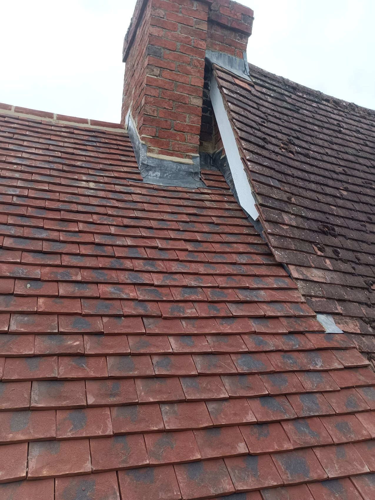 Old weathered tiles stripped off beside the chimney