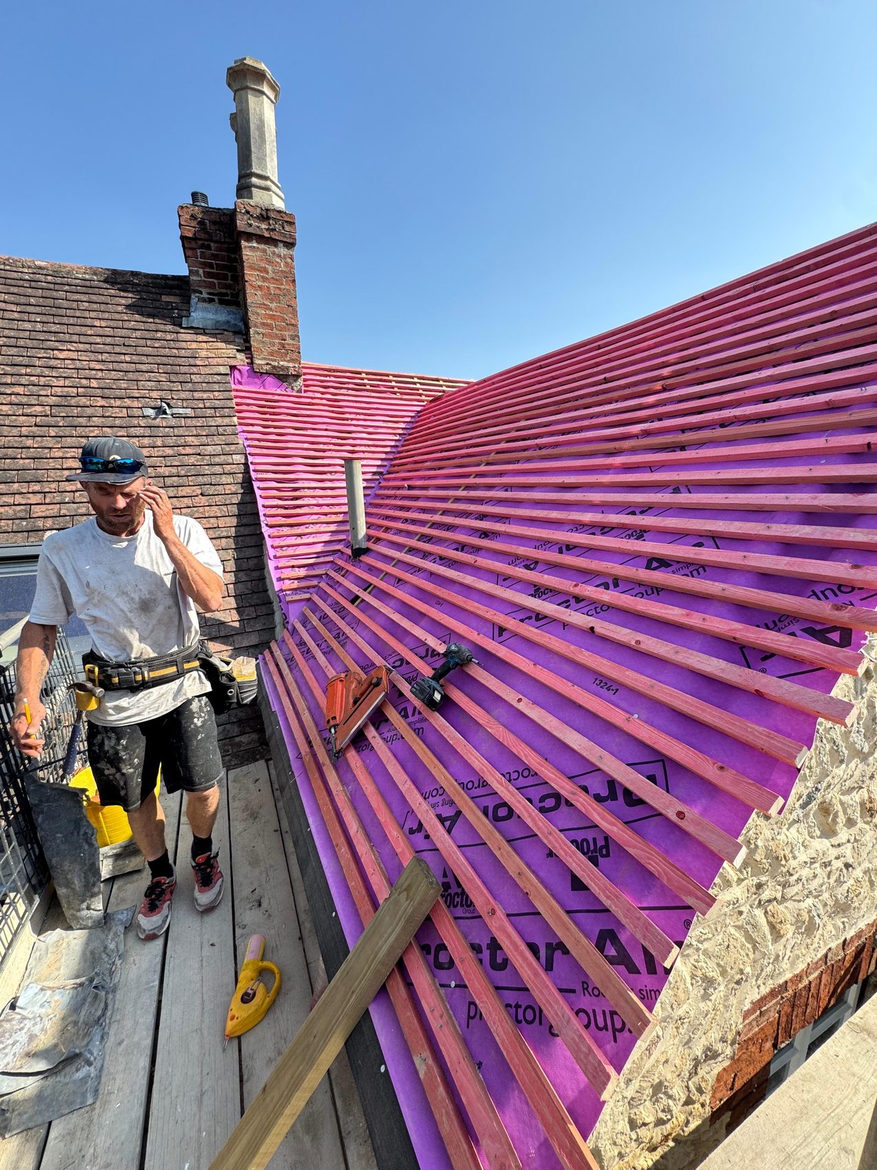 Roofer fixing treated battens to gauge over the membrane