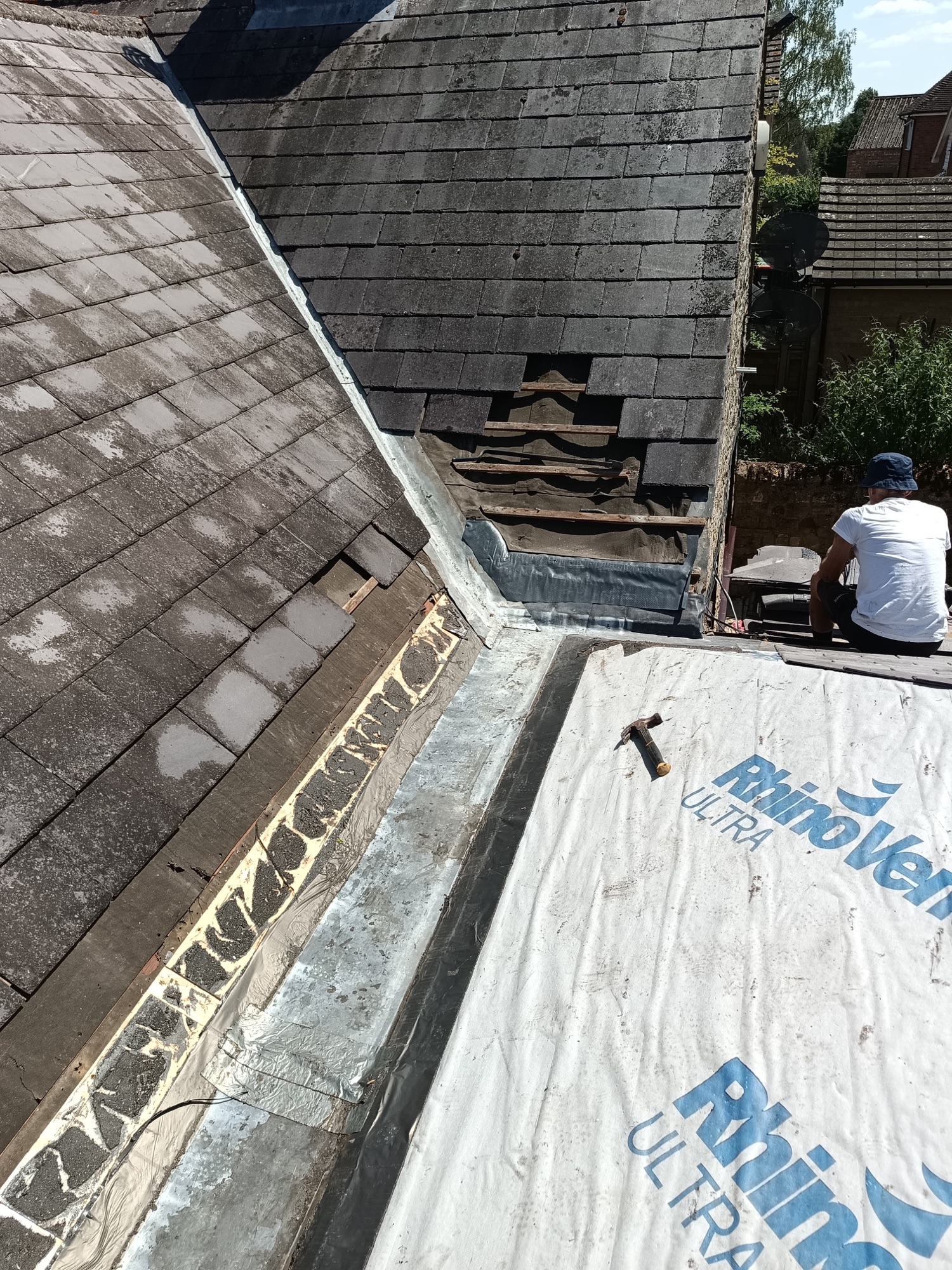 Breathable membrane laid in the box gutter and edges prepped, slates ready to dress back
